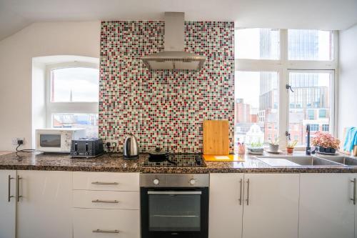 una cucina con lavandino e piano cottura forno superiore di Apartment Chinatown 306 a Newcastle upon Tyne