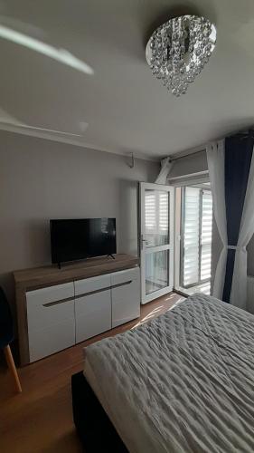 a bedroom with a bed and a flat screen tv at Kwatery prywatne in Międzyzdroje