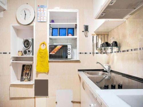 uma cozinha com um lavatório e um micro-ondas em APARTAMENTO MADRID Norte em San Sebastián de los Reyes