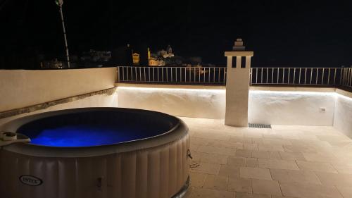 a hot tub and a lighthouse on a balcony at night at Via Roma 32 in Ostuni