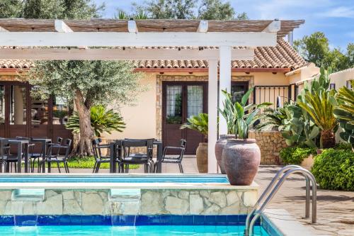 a pool with a pergola next to a house at Villa Felicia in Noto