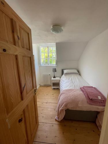 Schlafzimmer mit einem Bett und Holzboden in der Unterkunft Central townhouse in Woodstock