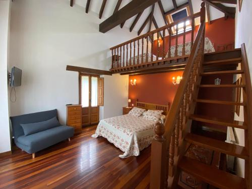 a bedroom with a staircase and a bed and a blue chair at La Posada de Abanillas in Abanillas