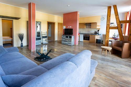 ein Wohnzimmer mit einem blauen Sofa und einer Küche in der Unterkunft FW Rheinblick in Sankt Goar
