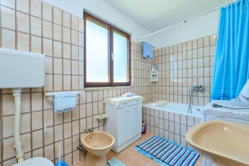 a bathroom with a toilet and a tub and a sink at Apartman Ana in Mali Lošinj