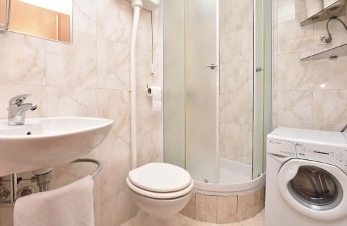 een badkamer met toilet, wastafel en wasmachine bij Apartment Mate in Omiš
