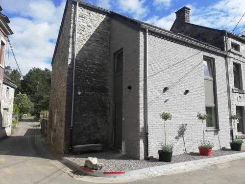 a brick building with a dog sitting in front of it at Thon chez toi in Andenne