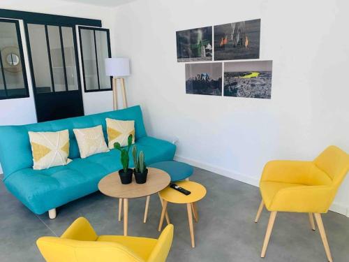 - un salon avec un canapé bleu et deux fauteuils jaunes dans l'établissement "Lou Mes" Baux-de-Provence Terrasse, aux Baux-de-Provence