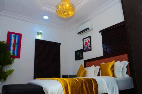 a bedroom with a bed with a yellow blanket on it at J Gibson Hotel in Lagos
