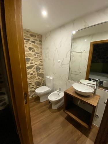 a bathroom with two toilets and a sink and a mirror at Casa da Mãe - Izei in Chaves
