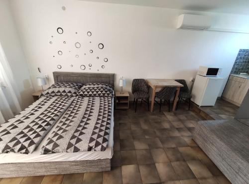 1 dormitorio con 1 cama y 1 mesa con sillas en Vasti Apartman, en Siófok