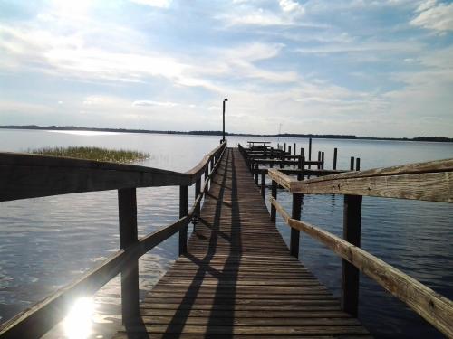 a dock on a body of water with the sun shining at Lakeside Inn and Cafe in Saint Cloud