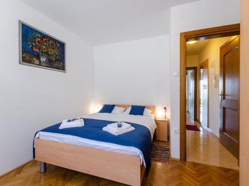 a bedroom with a large bed with a blue blanket at Apartment Nenad in Dramalj
