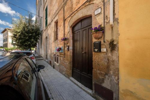 a car parked next to a building with a door at Sun Flowers House in Pitigliano