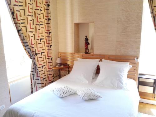 a bedroom with a white bed with two pillows at Izella in Douarnenez
