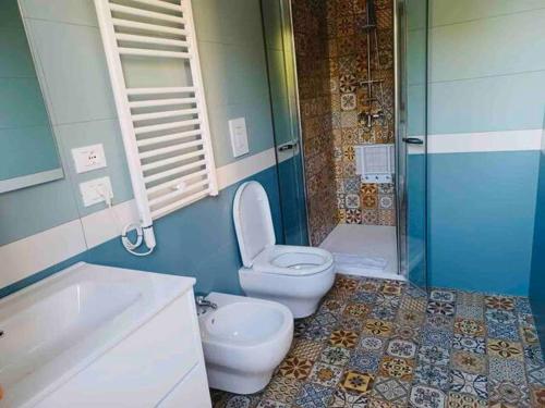 e bagno con servizi igienici, lavandino e doccia. di Villa Cycas a Casal Taulero