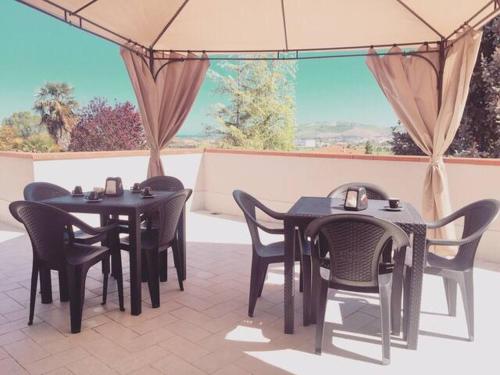 zwei schwarze Tische und Stühle auf einer Terrasse in der Unterkunft Villa Cycas in Casal Taulero