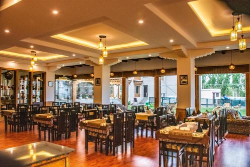 a dining room with tables and chairs in a restaurant at Ladakh Himalayan Retreat in Leh