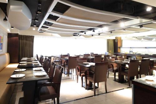 un comedor con mesas y sillas en un restaurante en K Hotel - Yunghe, en Yonghe