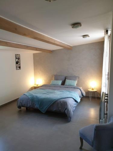 une chambre avec un grand lit et deux lampes dans l'établissement Au muret, à Salavas