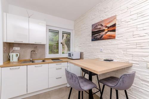 una cucina con tavolo in legno e 2 sedie di Apartments Marina a Trogir