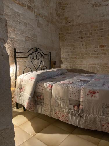 a bedroom with a bed in a brick wall at Trullo Zia Nina in Alberobello