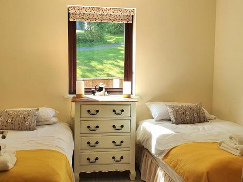 een slaapkamer met 2 aparte bedden en een raam bij Upper Rosemount Lodge in Blairgowrie