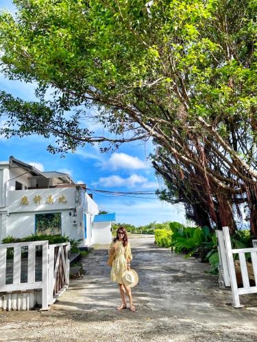 a woman in a yellow dress standing on a road at A Promised Land BnB in Jiufen