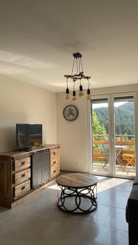 - un salon avec une table et une commode en bois dans l'établissement Le Pic Noir, à Gérardmer