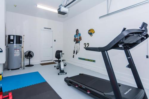 una sala fitness con tapis roulant e palestra di Enchanting Décor Home with private pool at Storey Lake Resort SL4714 a Kissimmee