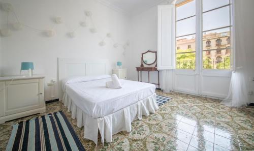 a white bedroom with a bed and a large window at TarracoHomes, TH160 Apartamento Rius in Tarragona