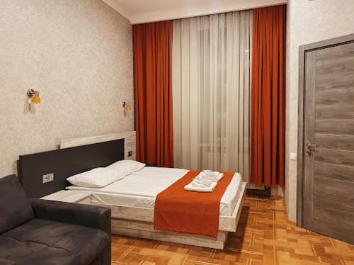 a bedroom with a bed and a couch at Apart-Hotel Shell in Tbilisi City