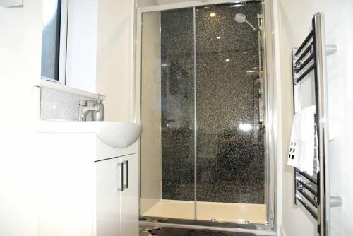 a shower with a glass door in a bathroom at Rammal Lodge - Entire home, self catering apartment in Inverness in Inverness