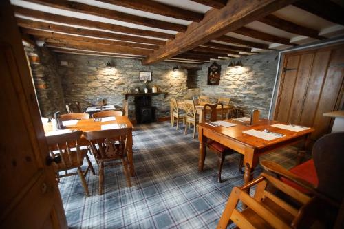 a dining room with wooden tables and chairs at The Dudley Arms in Llandrillo
