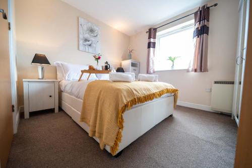 a bedroom with a bed with a yellow blanket on it at Neptune Marina in Ipswich