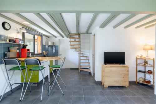 Il comprend une cuisine avec une table et des chaises ainsi qu'une télévision. dans l'établissement Chalet Piqueyrot, à Hourtin