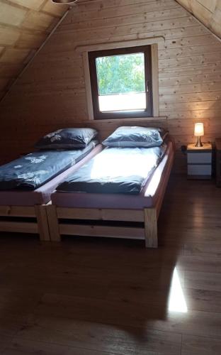 two twin beds in a room with a window at Przytulisko in Smołdzino