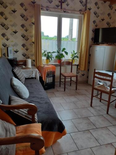 uma sala de estar com um sofá e uma janela em Studio du gite em Wavrans-sur-lʼAa