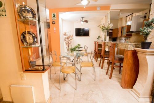 eine Küche und ein Esszimmer mit einem Tisch und Stühlen in der Unterkunft Hotel La Coruña in Piura