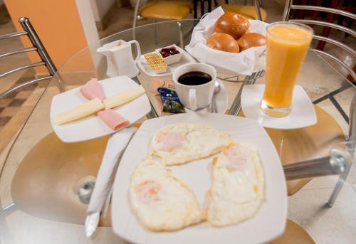 una mesa con un plato de comida y una bebida en Hotel La Coruña en Piura