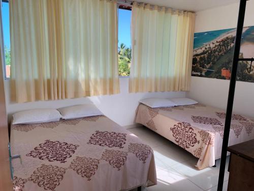 科魯里皮的住宿－Casa de temporada, Lagoa do Pau Coruripe-AL，一间卧室设有两张床和窗户。