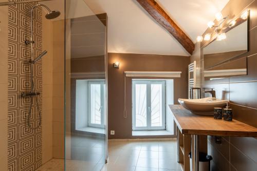a bathroom with a sink and a glass shower at Les Nuits Lupéennes in Lupé