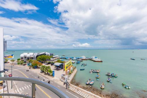Blick auf eine Stadt mit Booten im Wasser in der Unterkunft Joi Hospitality - Front Beach in Vũng Tàu