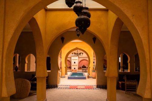 an archway in a building with a pool at RiadSuerteloca Merzouga in Merzouga