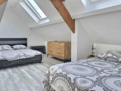 a bedroom with two beds and a dresser at En toute simplicité in Lavilletertre