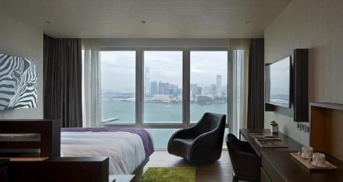 香港にあるCrafa Harbour Hotelのベッドと大きな窓が備わるホテルルームです。