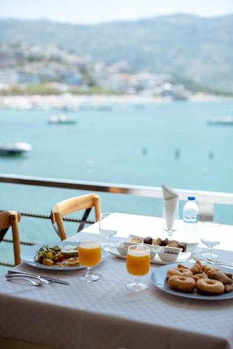 a table with plates of food and glasses of orange juice at Artis Blue Relax in Himare