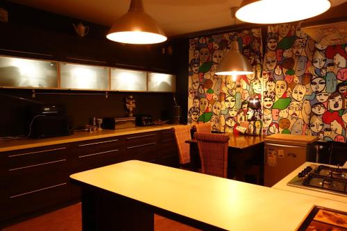 eine Küche mit einer Tapete mit Gesichtern an der Wand in der Unterkunft ARTgroturystyka Przystanek Błotna in Ostrów Podlaski
