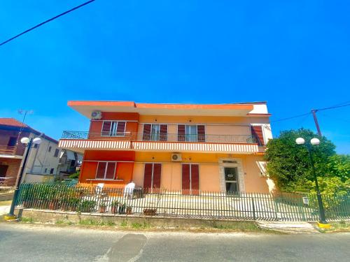 an orange house with a fence in front of it at Dimitris apartment in Diakopto