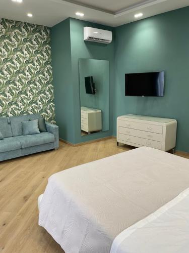 - une chambre avec un lit, un canapé et une télévision dans l'établissement M&M Guest House, à Ercolano